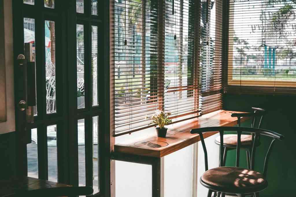 Warm, sunlit interior of the Eden Roasters cafe with wood tables and hanging pendant lights